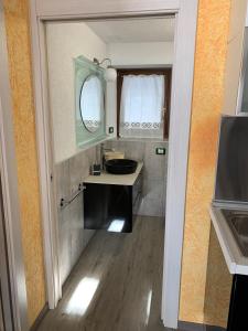 ein Bad mit einem Waschbecken und einem Spiegel in der Unterkunft Lo Miete de René in La Thuile
