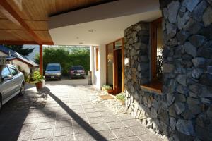 a stone building with cars parked in a parking lot at Hosteria Posta de los Colonos in Villa La Angostura