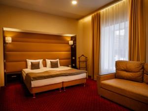 スモレンスクにあるPremier Hotelのベッドと椅子付きのホテルルーム