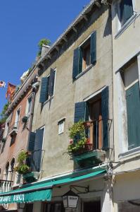 a building with blue shutters and flower boxes on it at Hotel Locanda Salieri in Venice
