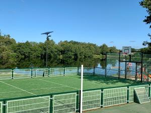 a tennis court with a tennis court at Gite du Moulin Toucan in Berneuil