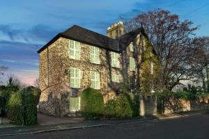 an old brick house with ivy on a street at Pages Hotel and Guesthouse in Harlow