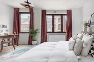 a bedroom with a large white bed with red curtains at Flemishome, The Retreat For Family And Friends in Halle
