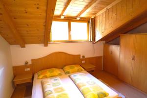 a small bedroom with two beds and a window at Unterbi Apartments in Appiano sulla Strada del Vino