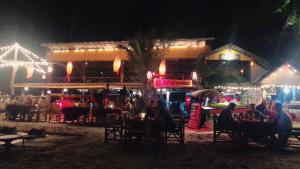 a group of people sitting at a restaurant at night at Moonwalk Lanta Resort in Ko Lanta