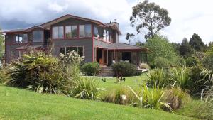 una casa con un perro caminando delante de ella en Paramata Lodge, en Kakapotahi