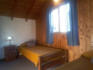 een kleine slaapkamer met een bed en een raam bij El Aguila in Bariloche