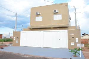 een gebouw met twee witte garagedeuren ervoor bij Tati's house Olímpia-casa para até 11 pessoas in Olímpia