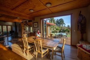 a man sitting at a dining room table in a house at Paramata Lodge in Kakapotahi