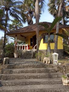 dom na plaży z palmami i schodami w obiekcie villa Arjuna w mieście Seraya