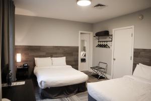 a hotel room with two beds and a closet at Auberge Valcartier in Saint-Gabriel-De-Valcartier