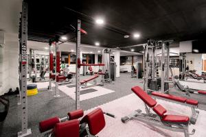 une salle de sport avec de nombreux fauteuils et machines rouges dans l'établissement Studio Hrebienok C211, à Starý Smokovec