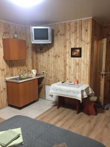 eine Küche mit einem Tisch und einem TV an der Wand in der Unterkunft Гостевой Дом «ANIKA» in Ivankov