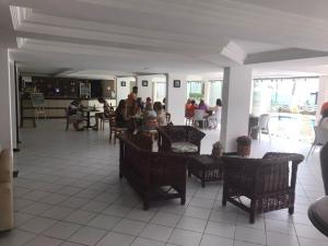 un grupo de personas sentadas en una mesa en un restaurante en Apart Hotel em Carneiros, Tamandaré., en Tamandaré