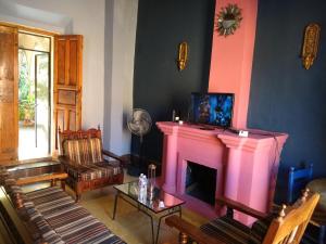 a living room with a fireplace with a pink at Casa Relox 23 in San Miguel de Allende