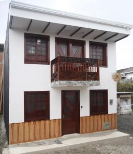 ein weißes Haus mit Balkon darüber in der Unterkunft Hotel Palmi in Salento