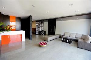 - un salon avec un canapé et une table dans l'établissement Astoria Hotels Madurai, à Madurai