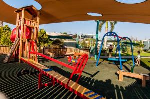 a playground with a slide and a swing set at Maagan Eden Holiday Village in Maagan