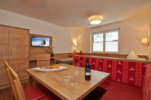 uma sala de jantar com uma mesa e uma garrafa de vinho em SöldenLiving Appartements em Sölden