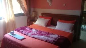 Un dormitorio con una cama con una caja. en Residence Les Calanques en Dakar