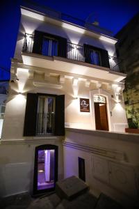 a large white building with a balcony at night at Luna Federiciana Luxury Room & Spa in Altamura