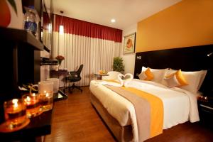 una habitación de hotel con una cama grande y una mesa en Astoria Hotels Madurai, en Madurai