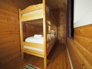 a room with two bunk beds in a log cabin at Eggum Rorbuer in Bøstad