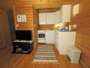 a kitchen with white appliances and a wooden wall at Eggum Rorbuer in Bøstad