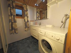 a laundry room with a washing machine and a sink at Eggum Rorbuer in Bøstad