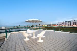 a table and chairs and an umbrella on a roof at Pousada Boi Bumbá Praia in João Pessoa