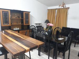 comedor con mesa de madera y sillas negras en Casa Temporaria en San Rafael