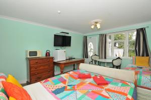 a bedroom with a bed and a living room at Richmond Guest House in Wellington