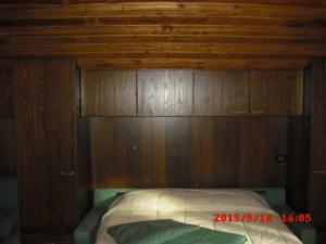 a bed in a room with a wooden wall at Lauson in Cogne