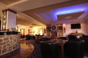 a hotel lobby with couches and a fireplace at Afkos Grammos Boutique Hotel Resort in Nestórion