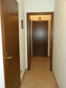 モンファルコーネにあるB&B L'Ormeggioの茶色のドアとタイルフロアの廊下