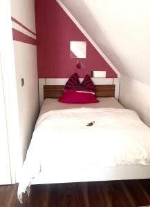 1 dormitorio con cama blanca y pared roja en Sweet Home, en Willich