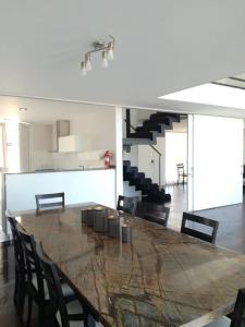 a dining room with a large wooden table and chairs at suites del champaqui in Villa General Belgrano