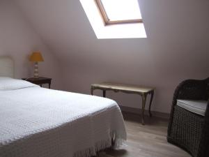 1 dormitorio con cama blanca y tragaluz en Penty de Kervillerm, en Douarnenez