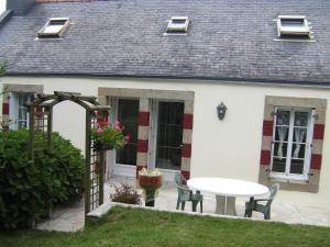 a patio with a table and chairs in front of a house at Penty de Kervillerm in Douarnenez