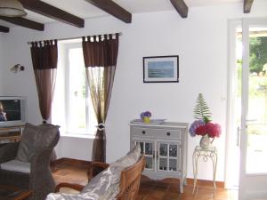 a living room with two chairs and a tv at Penty de Kervillerm in Douarnenez