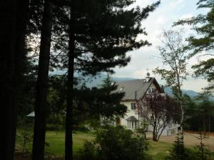 a white house with trees in the foreground at Caterina.C B&B in Val Della Torre