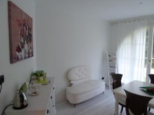 a living room with a white chair and a table at Caterina.C B&B in Val Della Torre