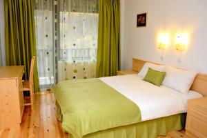 A bed or beds in a room at Family Hotel and Restaurant Plamena