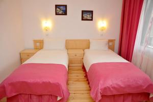 dos camas sentadas una al lado de la otra en una habitación en Family Hotel and Restaurant Plamena, en Oreshak