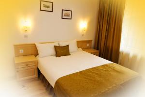 A bed or beds in a room at Family Hotel and Restaurant Plamena
