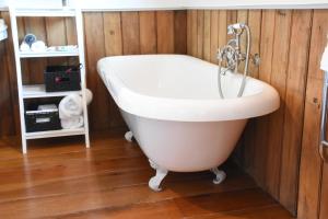 a bathroom with a bath tub and a sink at Shy Cottage and Studio in Greytown