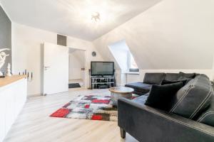 sala de estar con sofá y TV en Private Apartment, en Hannover