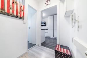 un pasillo con una puerta que conduce a una cocina con armarios blancos en Private Apartment, en Hannover