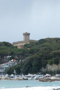 a castle on top of a hill next to the ocean at Hotel Signorini in Castiglioncello