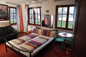 a couch in a living room with a table and windows at Haus Enteresan in Cologne